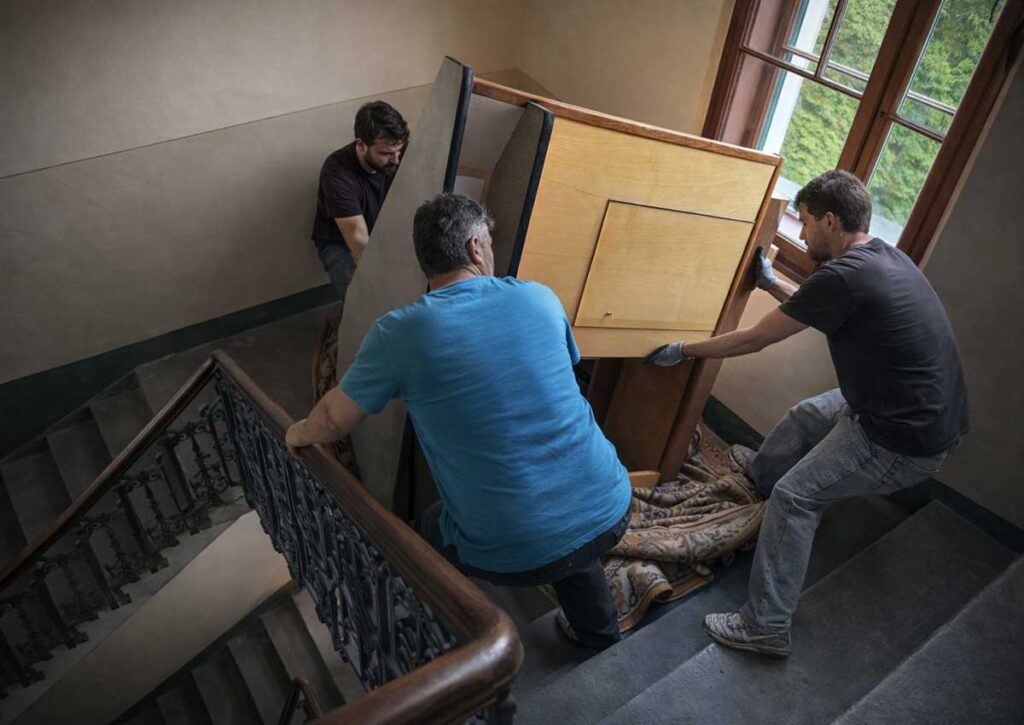 Mitarbeiter tragen schweren Schrank – Möbelentsorgung Graz